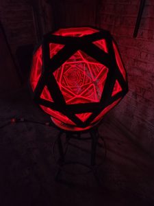 Vibrant red LED geometric art sculpture by Chris Knight Creations, illuminated for modern decor.