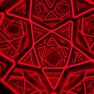 Vibrant red neon geometric star sculpture with intricate interconnected patterns, modern art piece for interior or exterior decor.