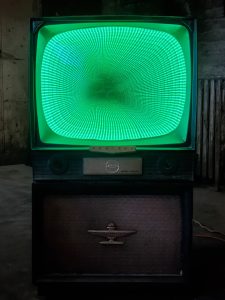 Vintage green neon TV with swirling tunnel display, modern retro-inspired custom design, perfect for vintage decor and art installations.
