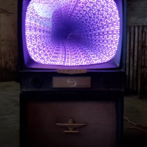 Vintage neon TV with vibrant purple and blue LED lights, showcasing electronic and retro entertainment art.