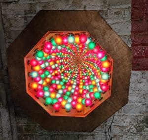 Colorful glowing orb light art by Chris Knight Creations, vibrant wall decor for modern interiors, LED art installation.