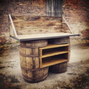 Rustic barrel outdoor bar with wood shelving and backrest for home entertainment and patio decor.