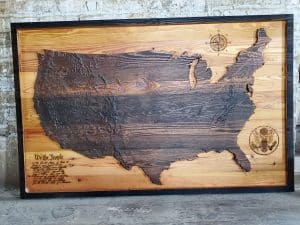 Handcrafted wooden map of the United States with engraved states and artistic details.
