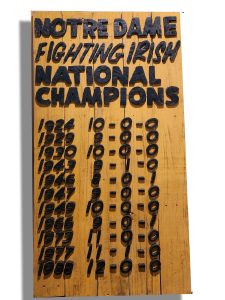 Handcrafted wooden sign celebrating Notre Dame Fighting Irish football championship wins.